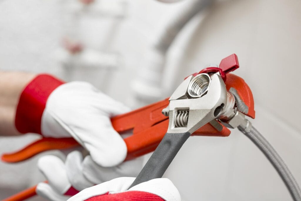 Plumber holding pipe wrenches for an emergency repair in Palm Beach Gardens