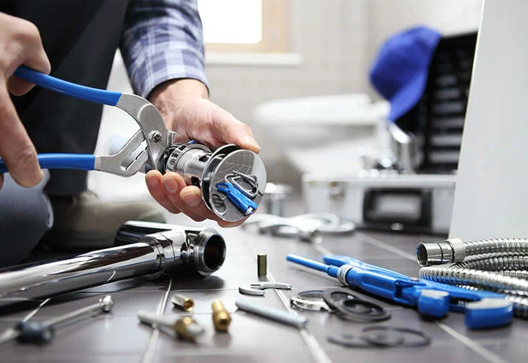 Technician repairing a plumbing fixture with professional tools in Palm Beach Gardens