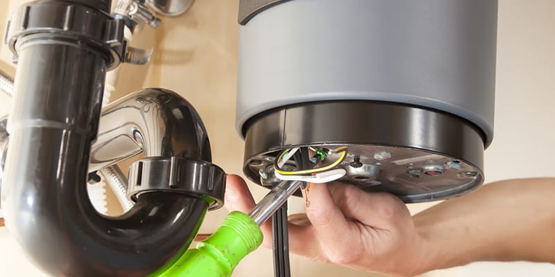 Technician repairing the heating element of a water heater in Palm Beach Gardens