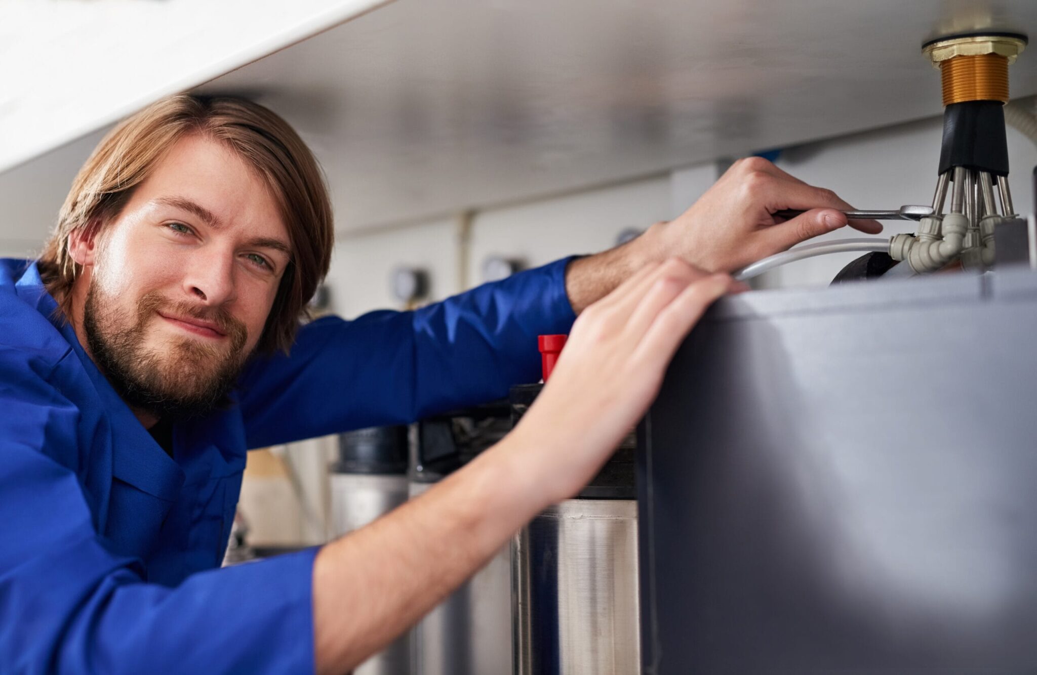 Technician servicing a residential water heater tank in Palm Beach Gardens