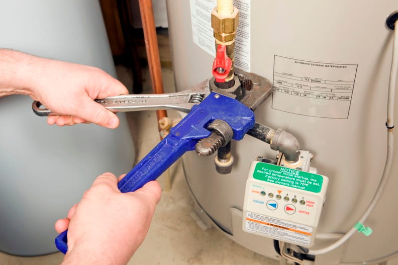 Plumber repairing a water heater valve in Palm Beach Gardens
